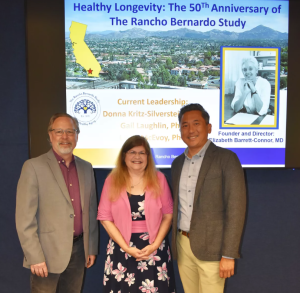 Gerald Shadel, Donna Kritz-Silverstein and Anthony Molina are among the researchers utilizing the data from the Rancho Bernardo Heart and Chronic Disease Study. On the screen behind them is a photo of the late Dr. Elizabeth Barrett-Connor, who founded and led the study from 1971 until her death in 2019. (Courtesy of RB Health Study)